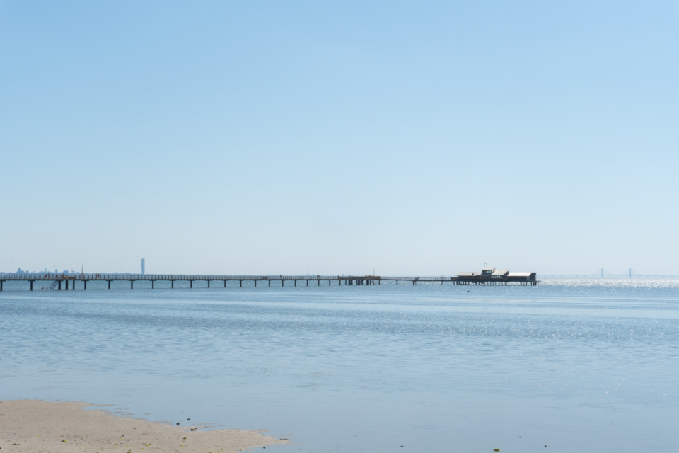 Långa Bryggan (”The long jetty”) in Bjärred, with Malmö in the background. The skyskraper Turning Torso and the Øresund bridge are visible.