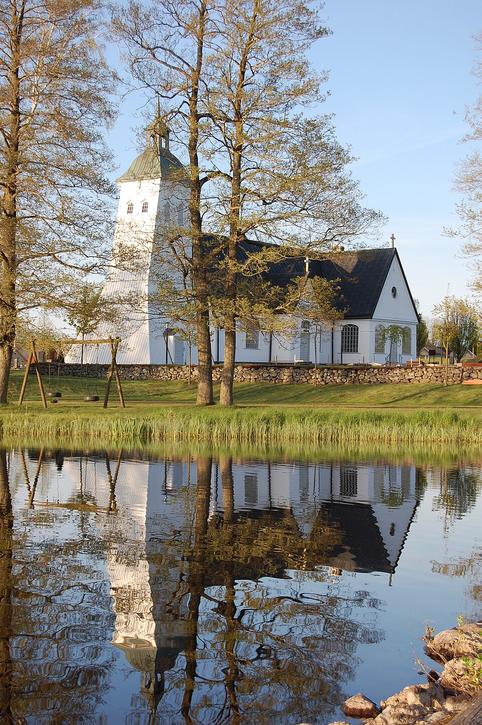 Tävelsås kyrka som sedd från badbryggan bakom skolan.