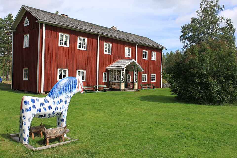 Framsidan av Fågelsjö Gammelgård med trähästen.